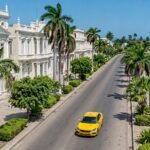 Coche amarillo moderno frente a la bahía de Cienfuegos