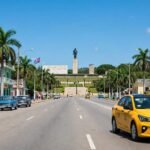 Coche amarillo moderno junto al monumento al Che Guevara en Santa Clara